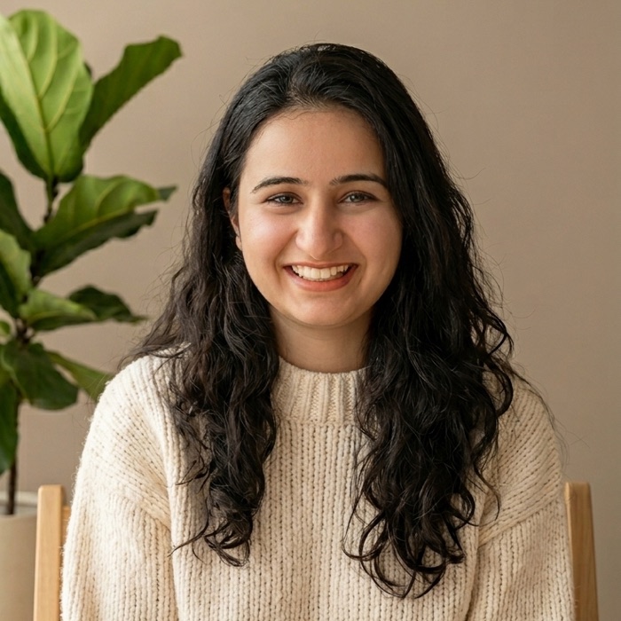 Arya Dhembre, psychologist and therapist, smiling in a warm, calm room