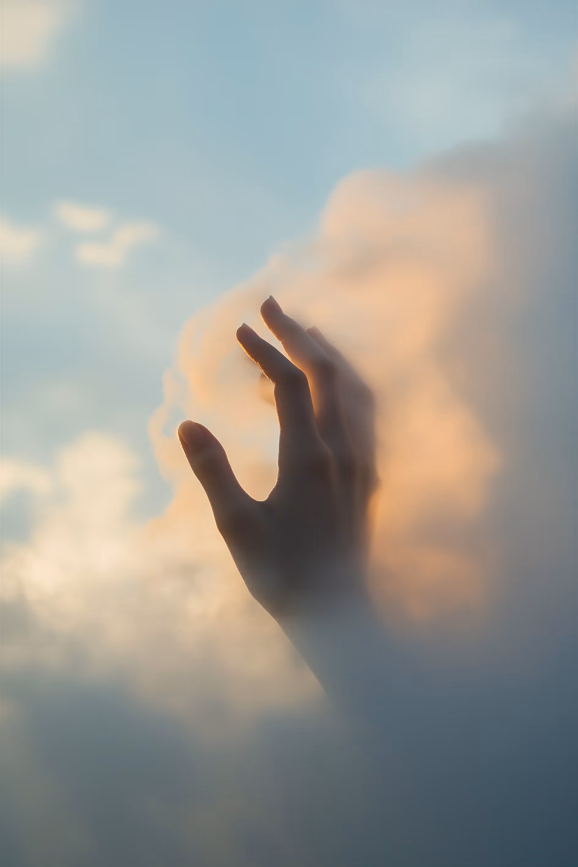 Hand reaching through ethereal cloud representing support through life transitions.